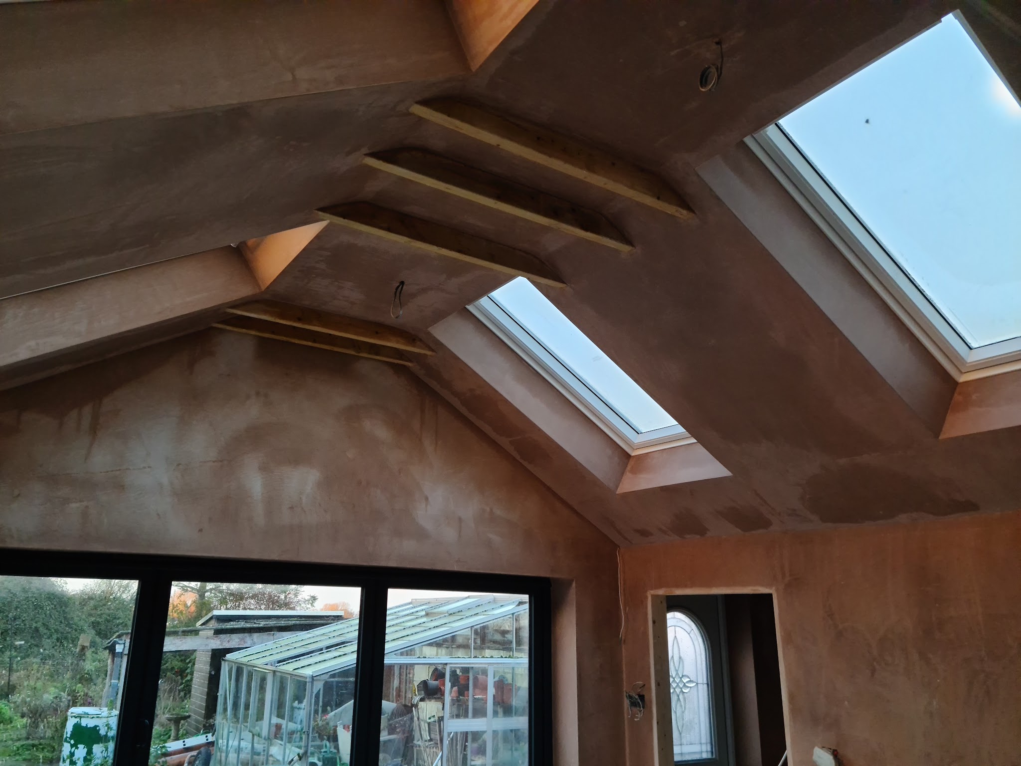 Plastered vaulted room with roof windows and timber beams