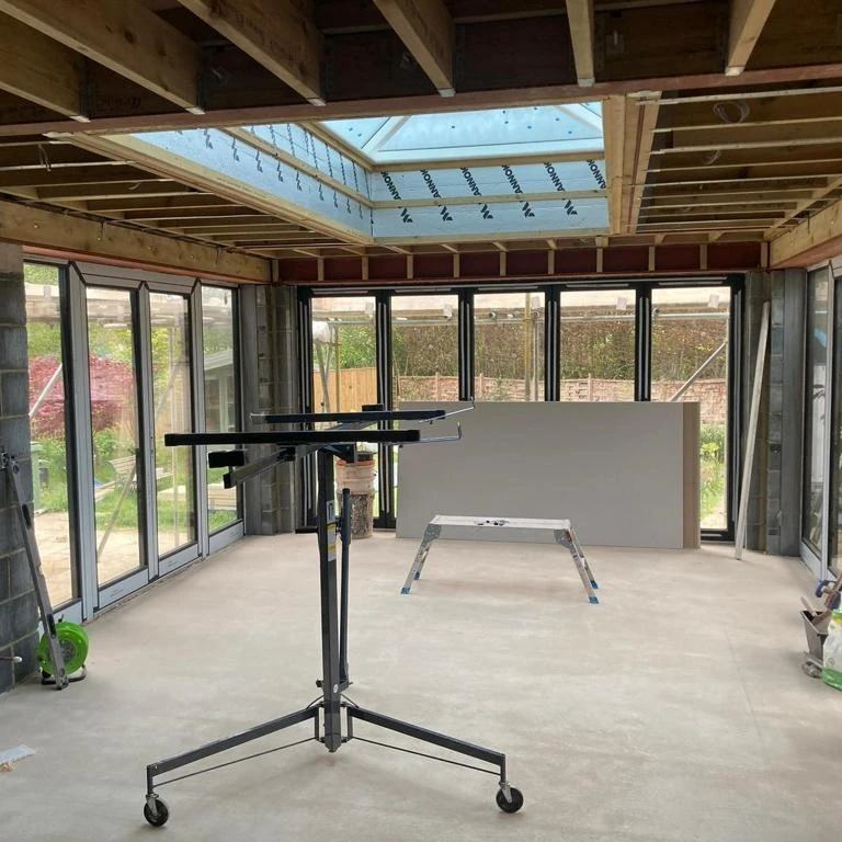 Extension interior with a plasterboard lifter ready to board the ceiling