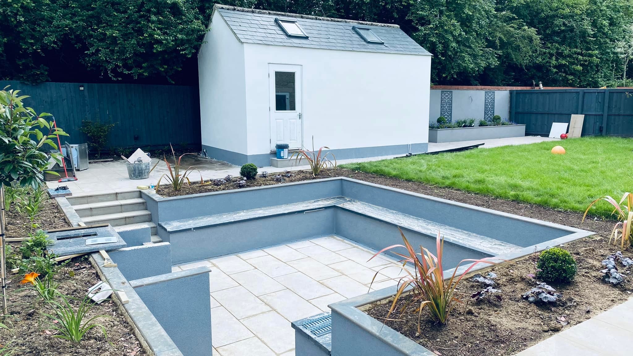A new garden with a sunken patio, steps and rendered raised beds