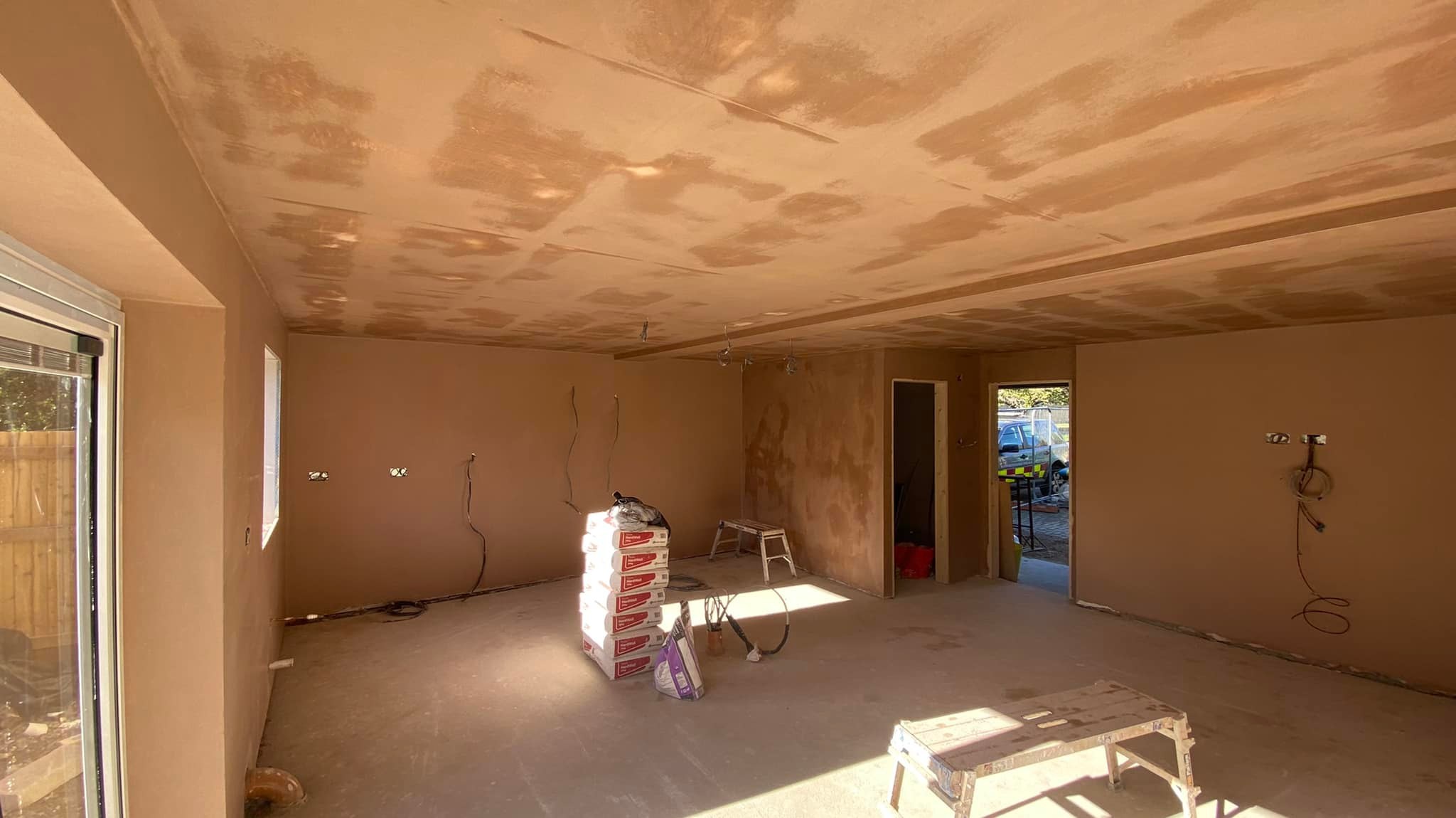 Large open room with newly plastered walls and ceiling