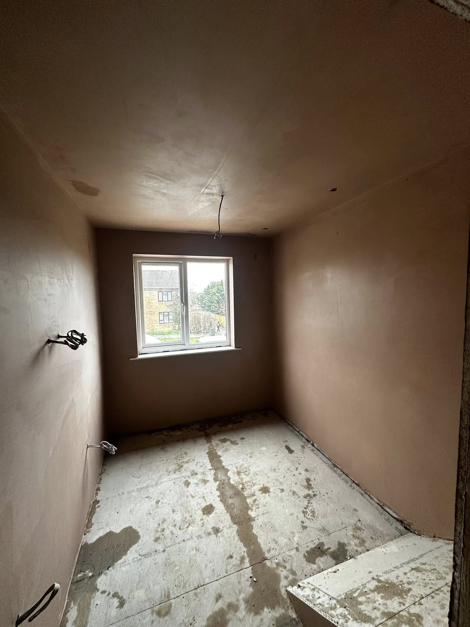 Bedroom with fresh plaster on walls and ceiling