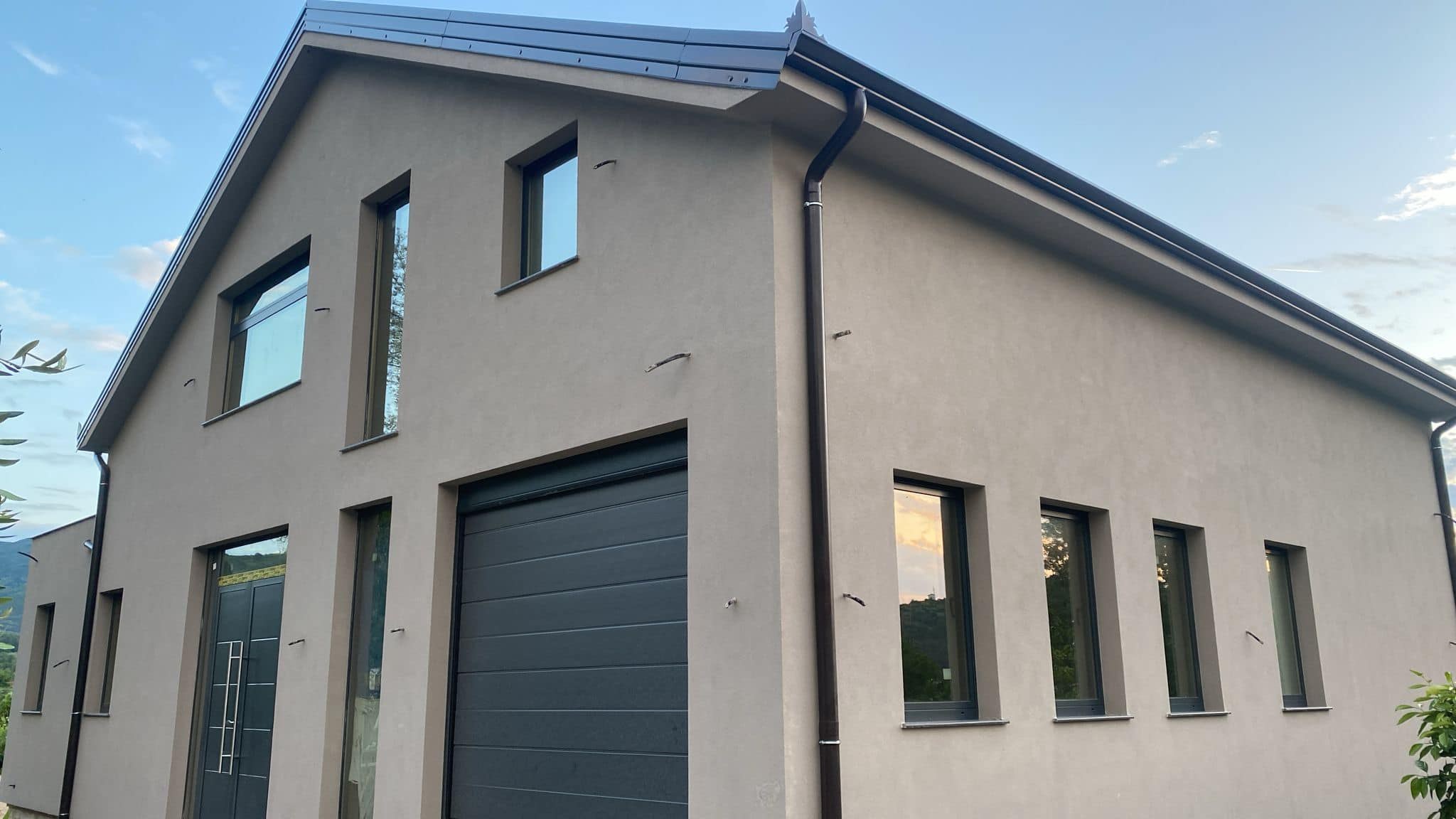 Modern grey rendered house with a garage door